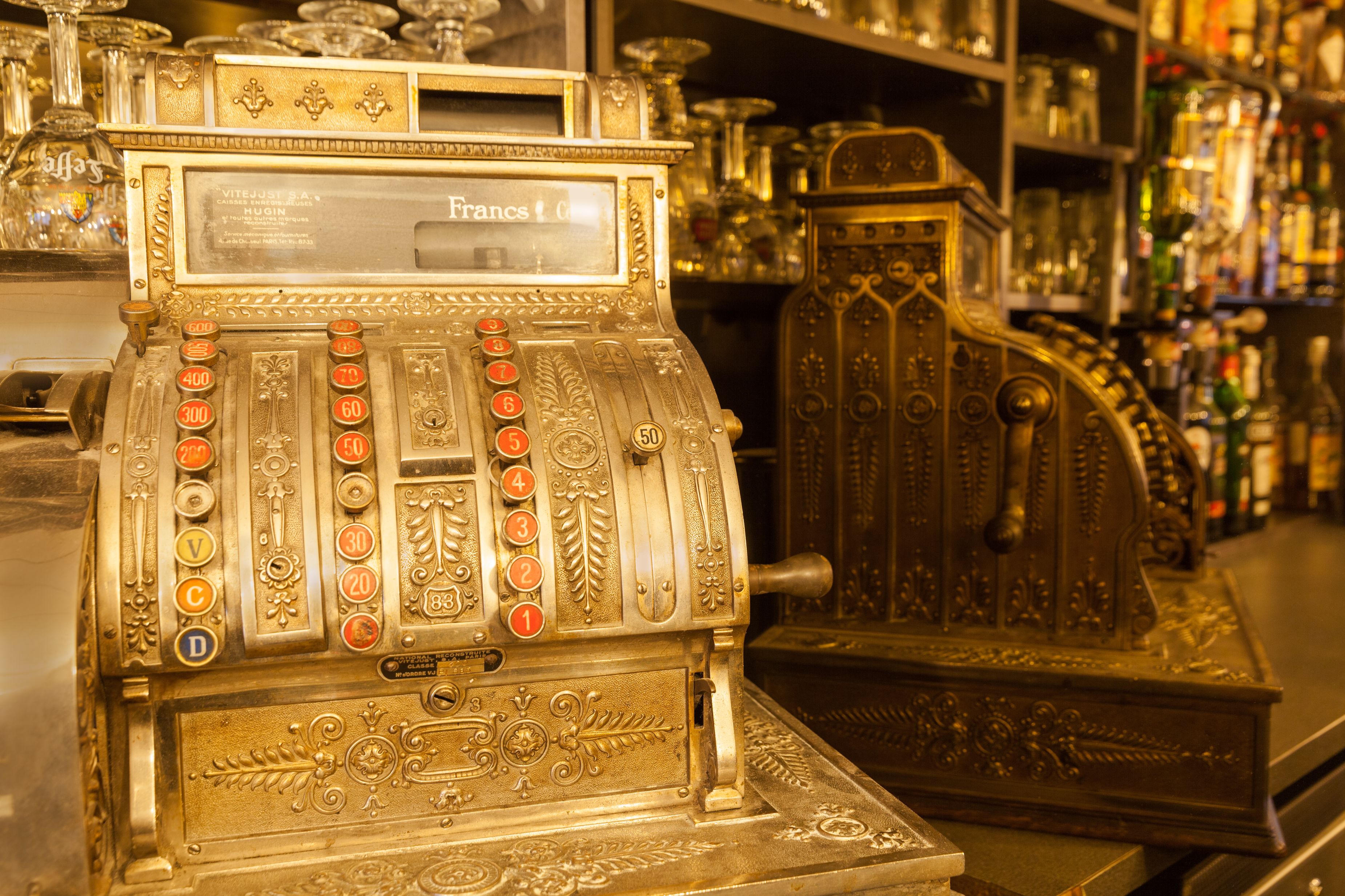 Una máquina tragamonedas ornamentada con diseño antiguo, que incluye un indicador de pago en efectivo y una palanca.