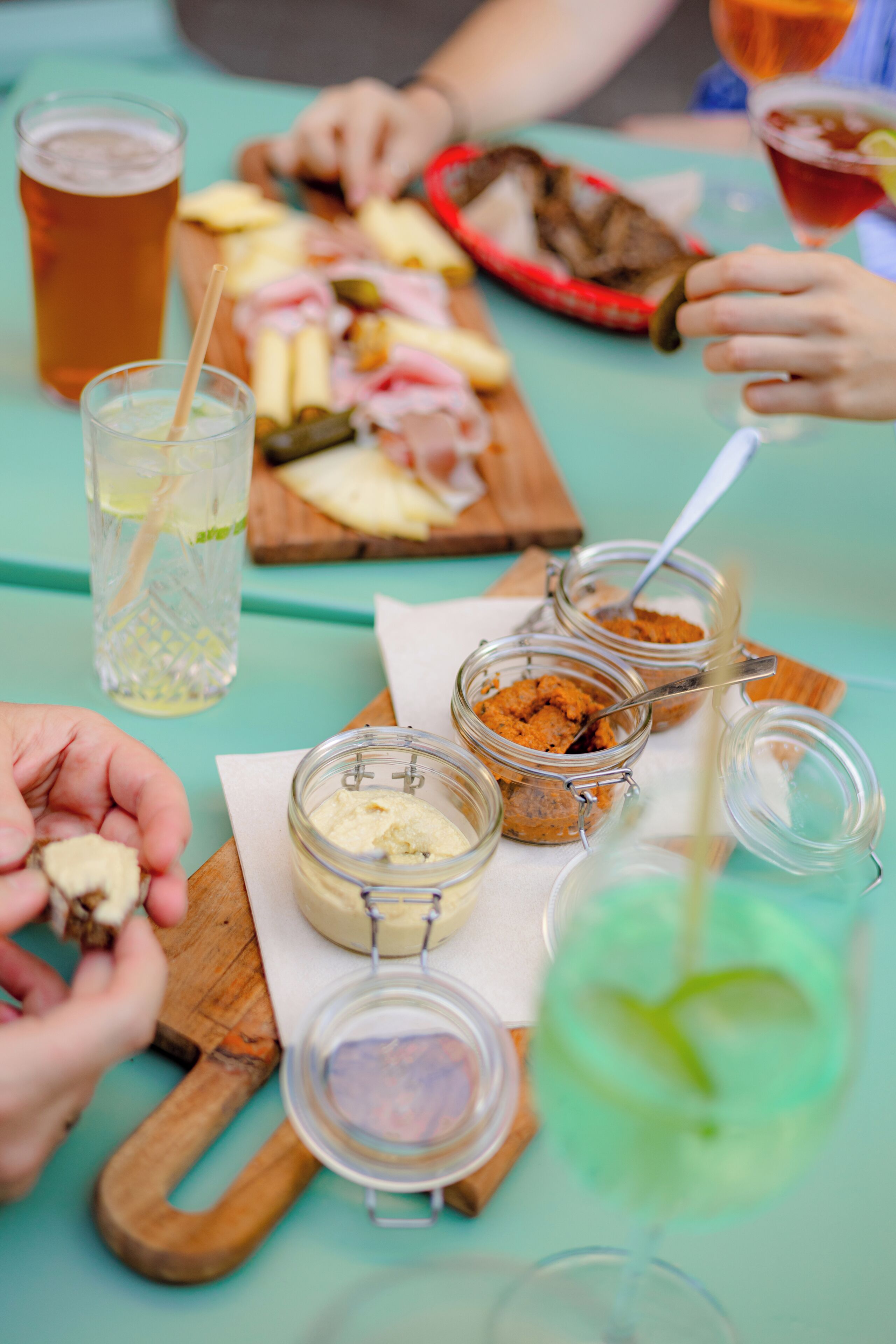 A table with food, drinks, and jars of condiments.