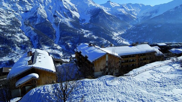A snow-covered mountain village with wooden buildings and a clear blue sky. - Noemys Le Pra Palier (Orcieres)
