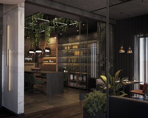 A modern interior with a bar area, seating, and a kitchen visible through glass partitions.