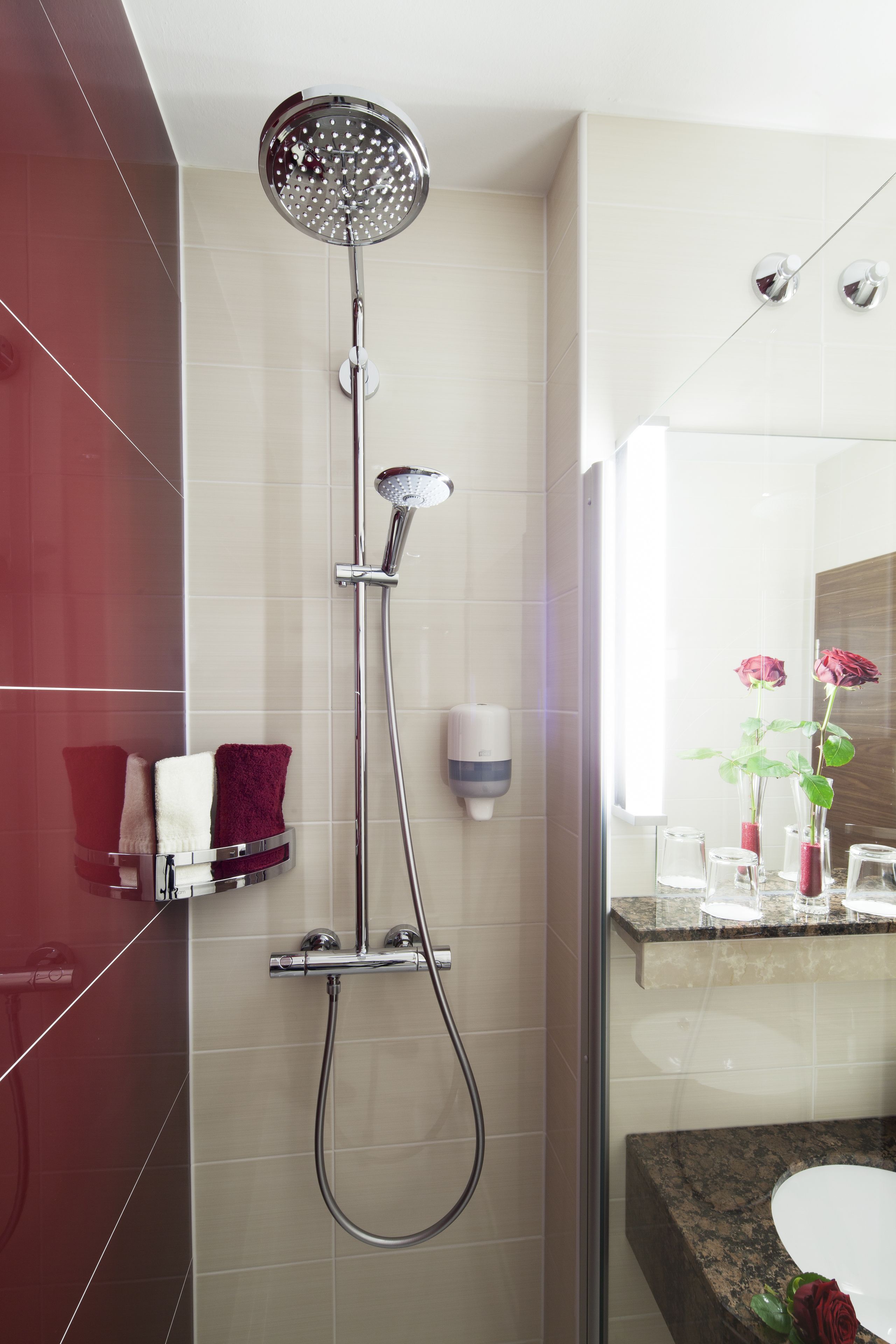 A modern bathroom with a glass-enclosed shower, a marble countertop, and a mirror above the sink.