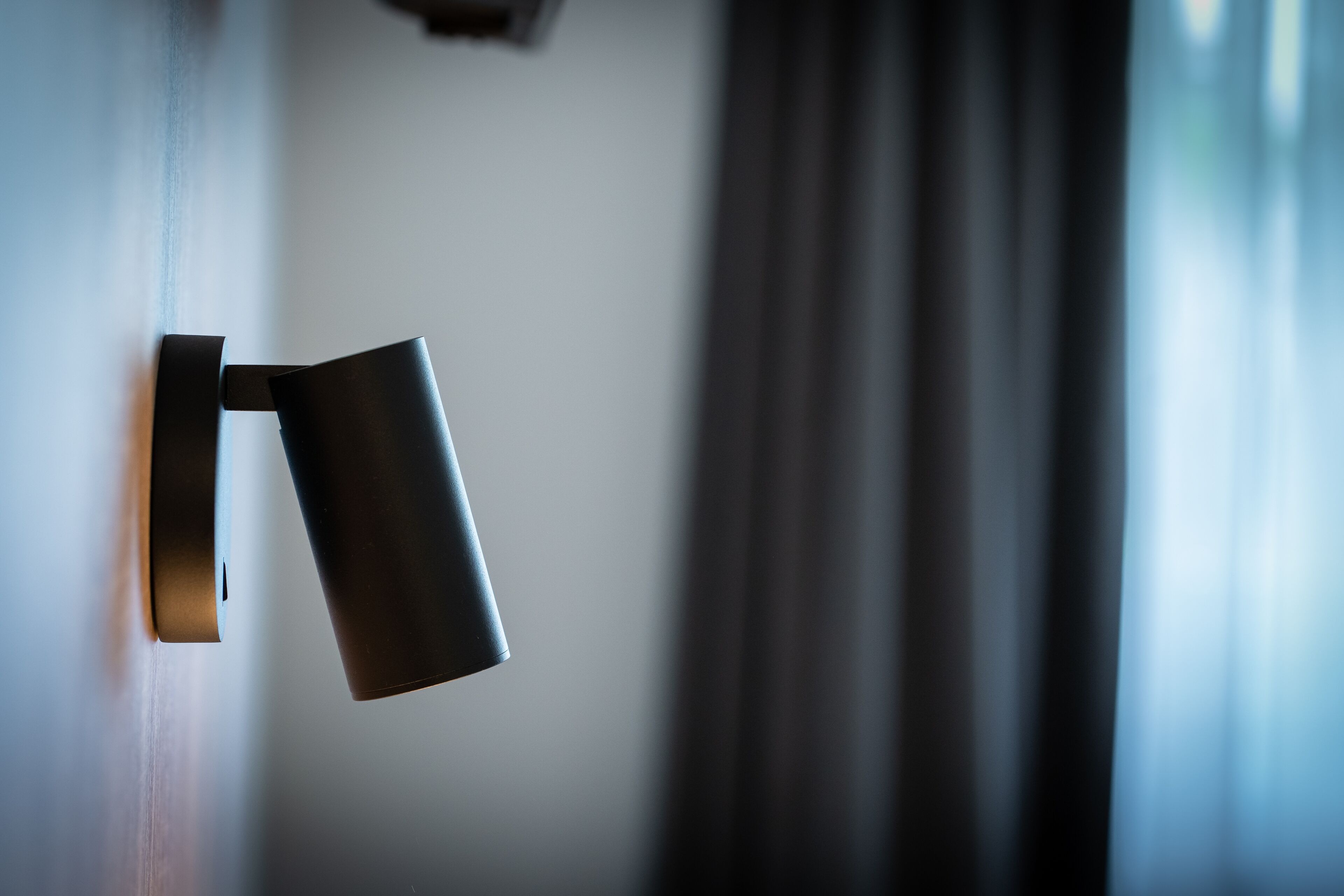 Un moderno e slanciato apparecchio di illuminazione a parete in una stanza poco illuminata.