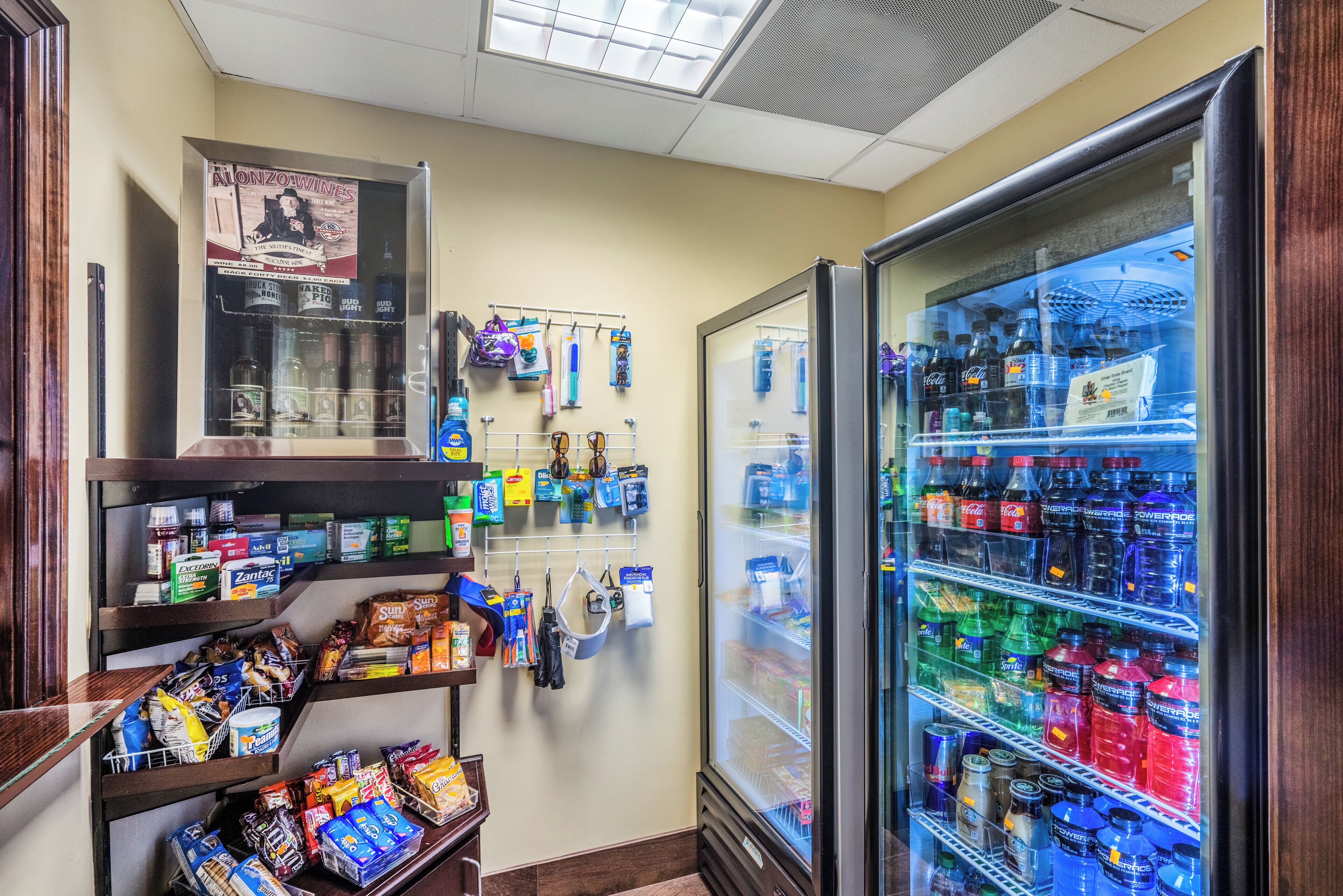 A convenience store with a refrigerated beverage display and shelves stocked with snacks and personal care items.