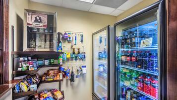 A convenience store with a refrigerated beverage display and shelves stocked with snacks and personal care items.