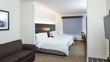 Ein Hotelzimmer mit einem Bett, einer Couch, einem Schreibtisch und einem großen Fenster.