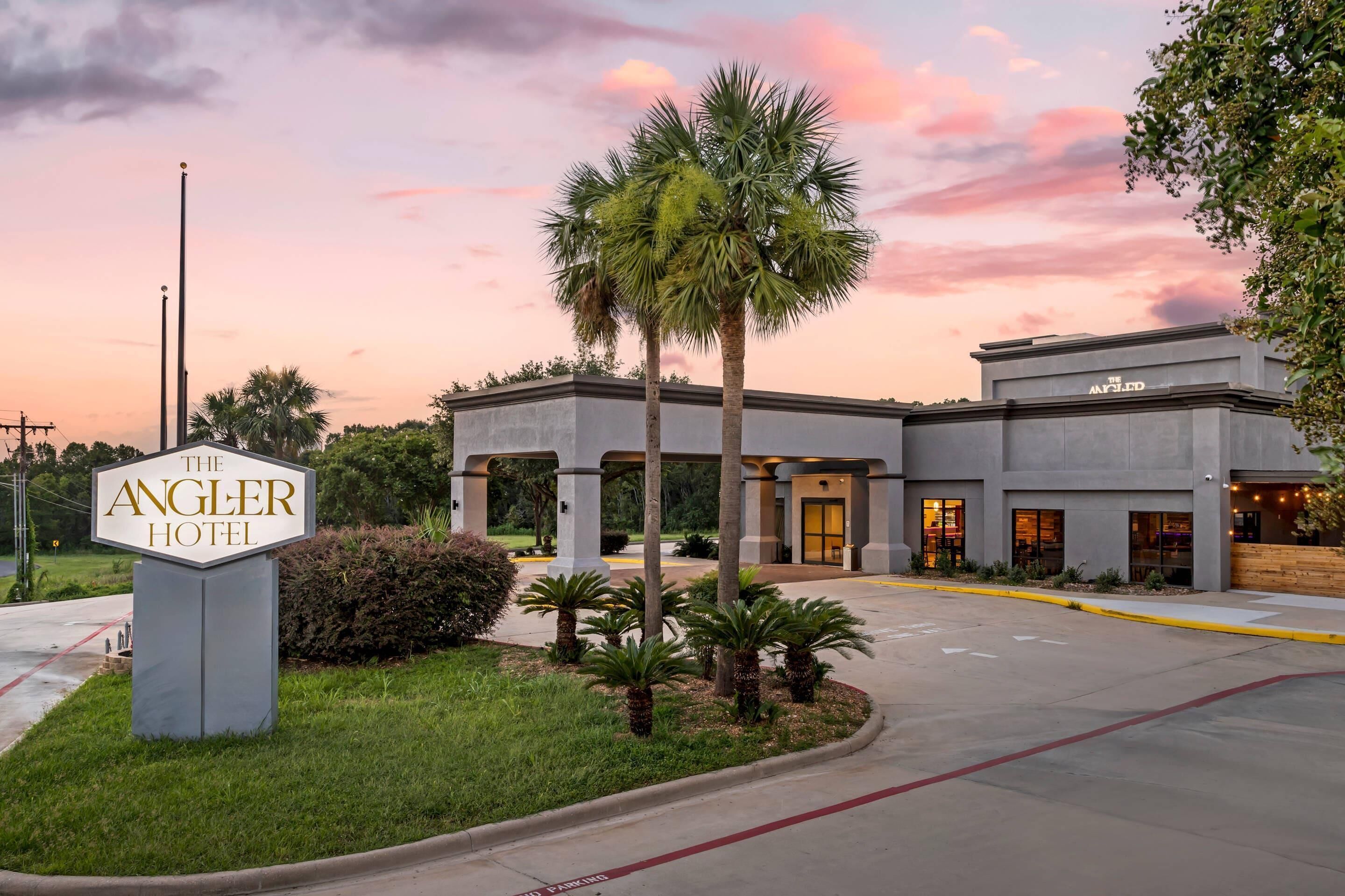 The Angler Hotel with a modern facade, palm trees, and a signboard.