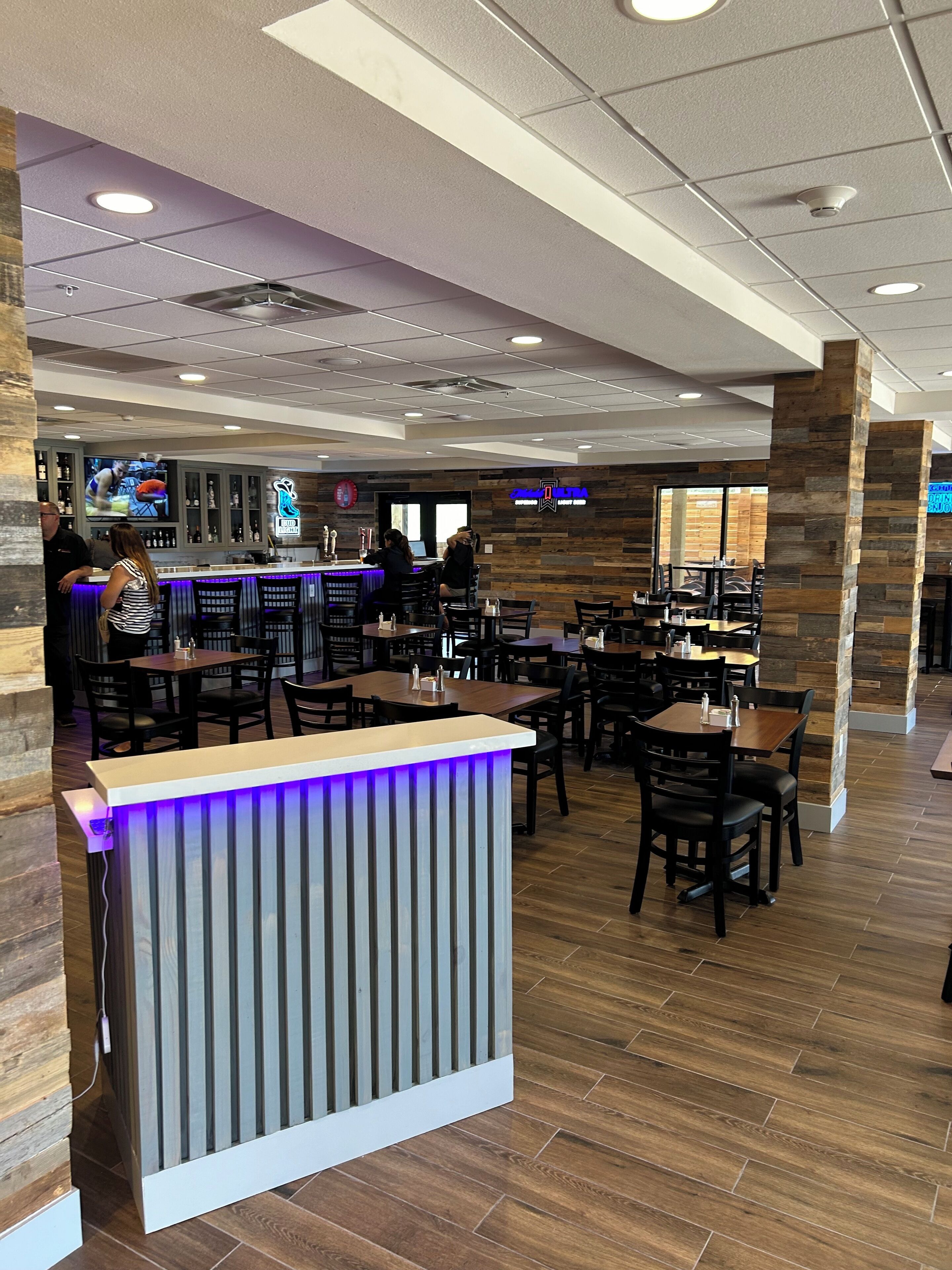 Ein Restaurant mit Barbereich, Holzboden und modernem Interieur.