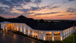 A modern building with multiple windows and a flat roof, surrounded by greenery. - Løgstør Parkhotel (Logstor)