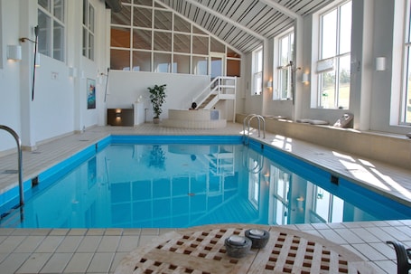Una piscina techada, sillones reclinables de piscina