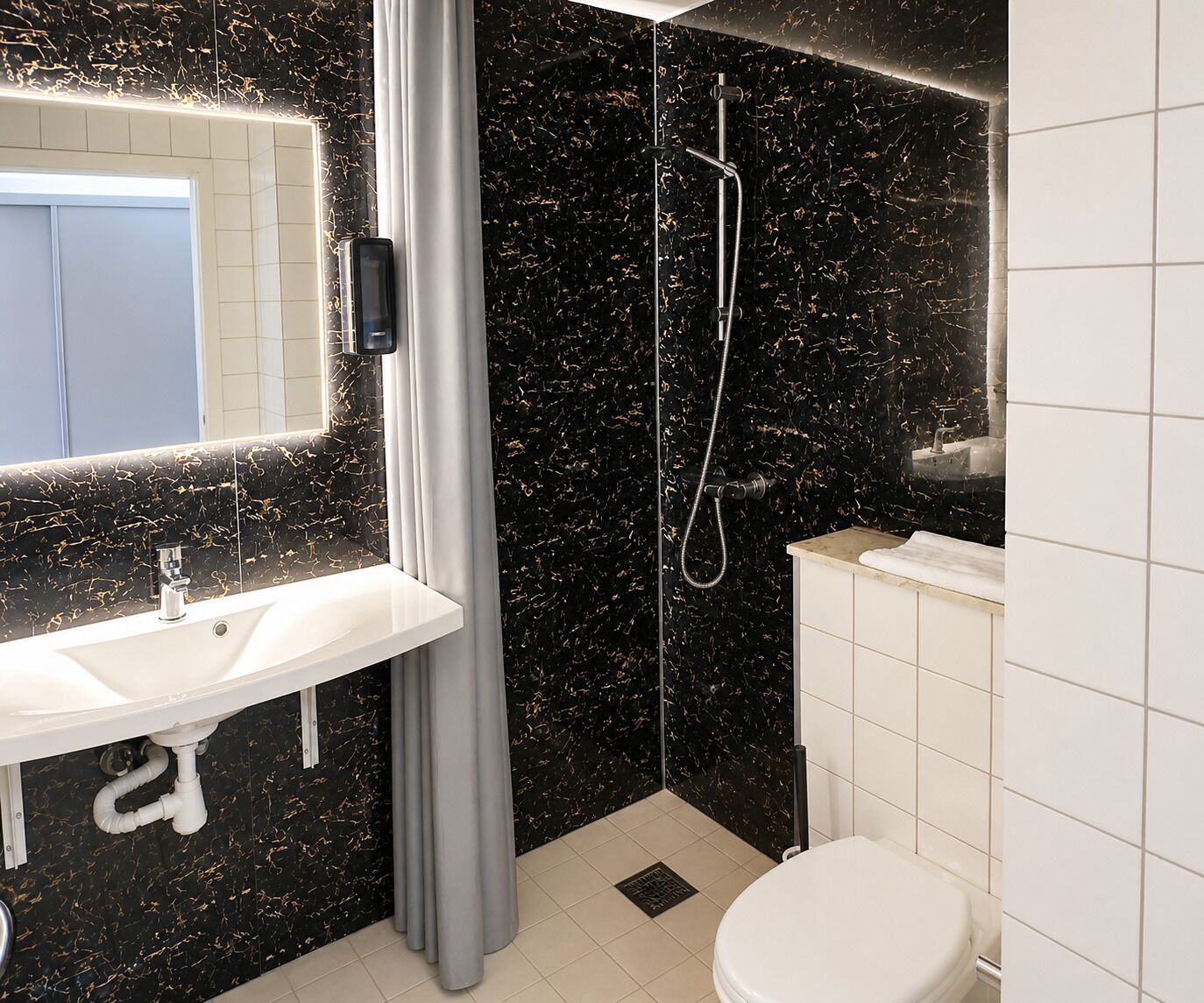 A modern bathroom with a white sink, a shower, and a toilet.