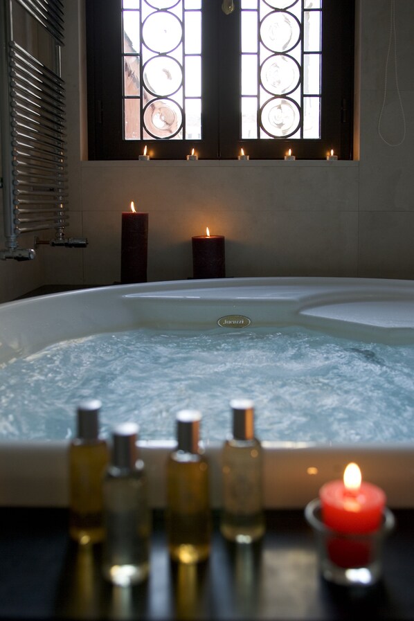 A spa bath with candles and essential oils.