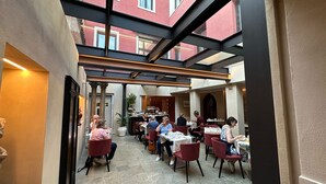 Un restaurante con una decoración moderna, que incluye un entrepiso y sillas rojas.
