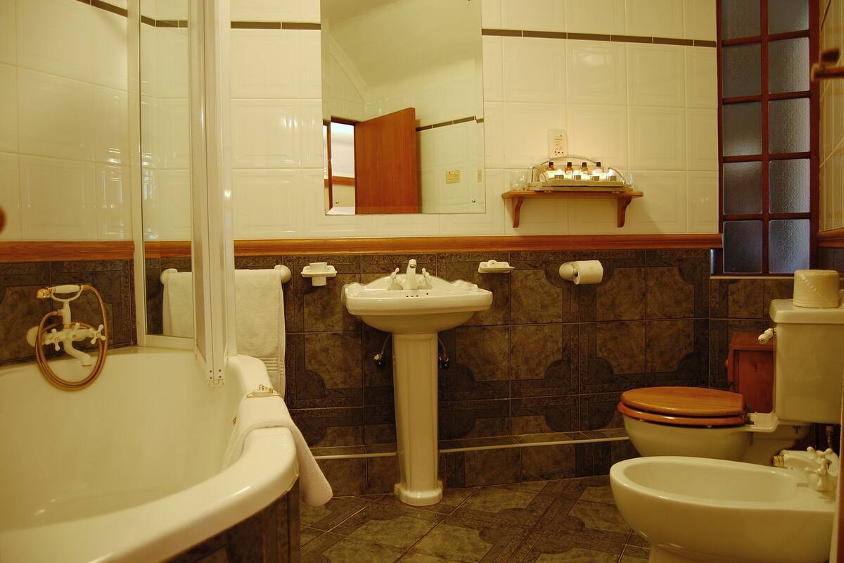 Een bad/douchecombinatie, een diep bad, designer toiletartikelen
