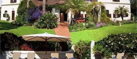 Alberca al aire libre, sombrillas en la alberca y camastros