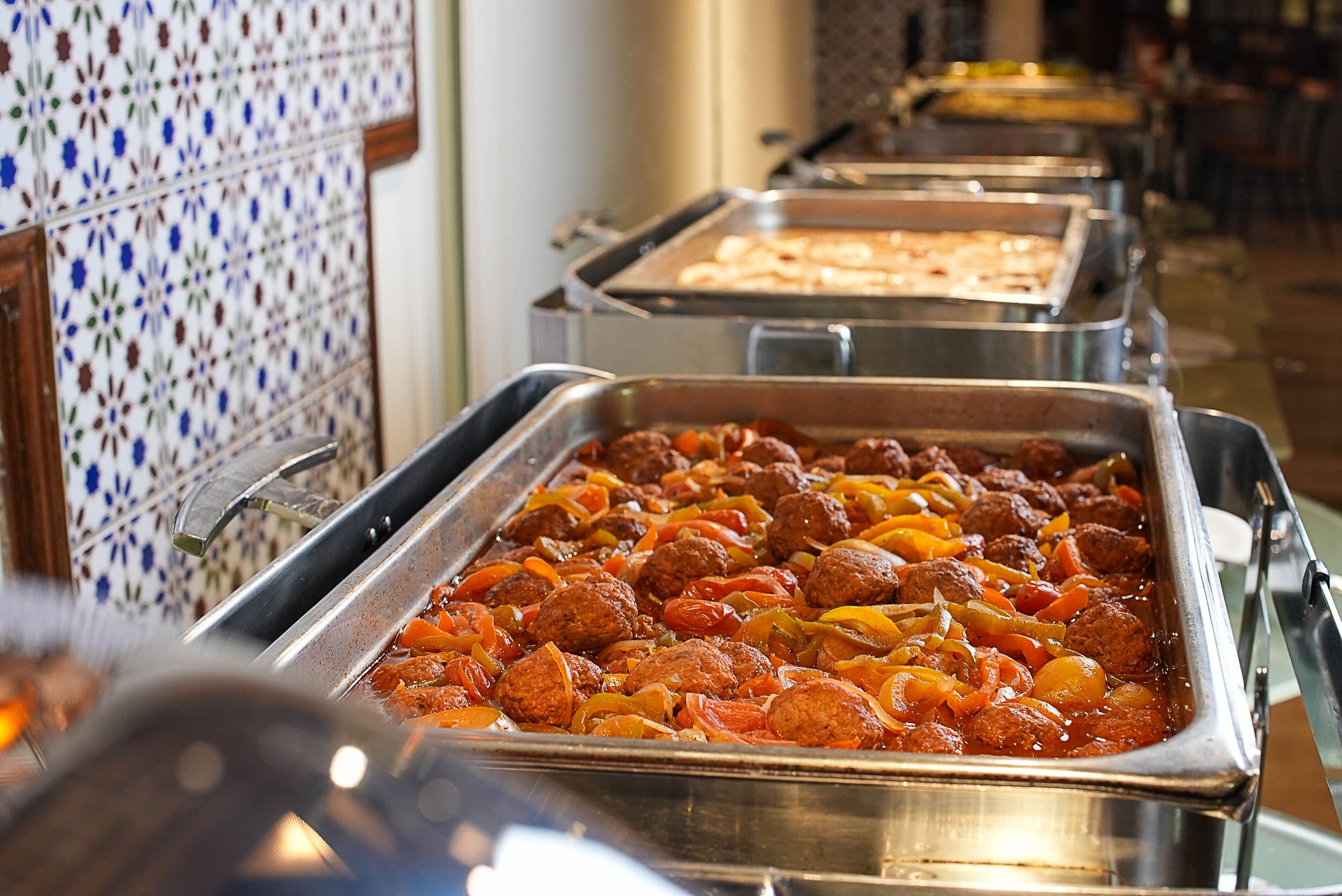 A buffet with various dishes including meatballs and vegetables.