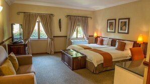 Une chambre d’hôtel avec un lit, un canapé, un bureau et une télévision.