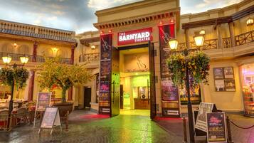 Teatro Barnyard con toldo, zona de estar al aire libre y plantas decorativas.