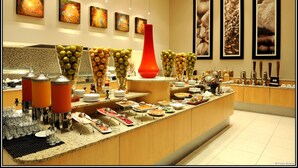 Ein reichhaltiges Buffet mit verschiedenen Speisen und einer zentral platzierten roten Vase.