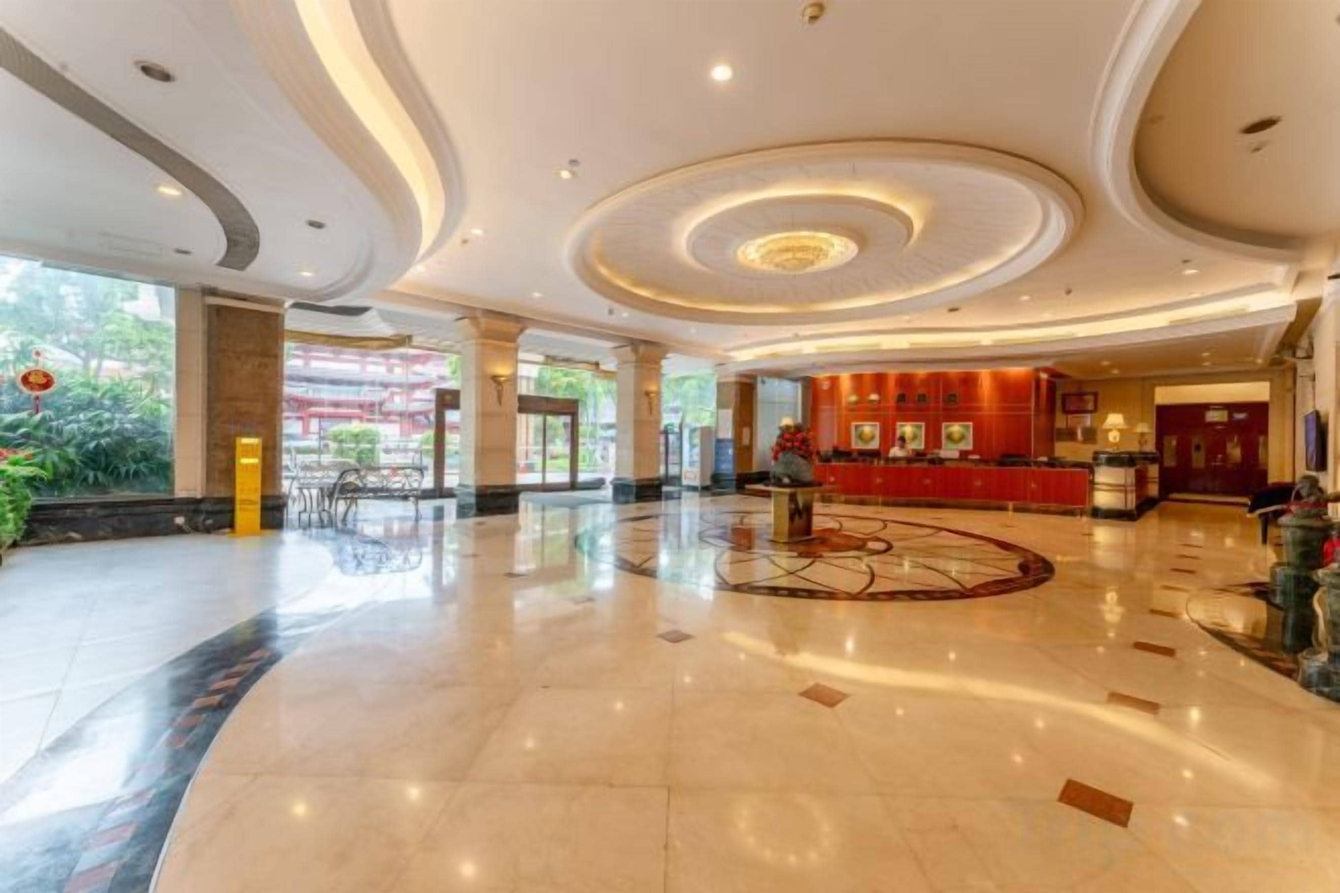 A spacious lobby with a central circular design, a reception desk, and a view of the outdoors.