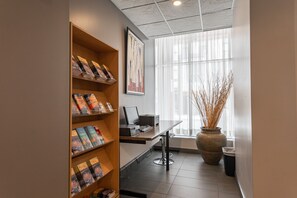 A modern office space with a desk, computer, and shelves with books. - Hotel Labelle (Montreal)