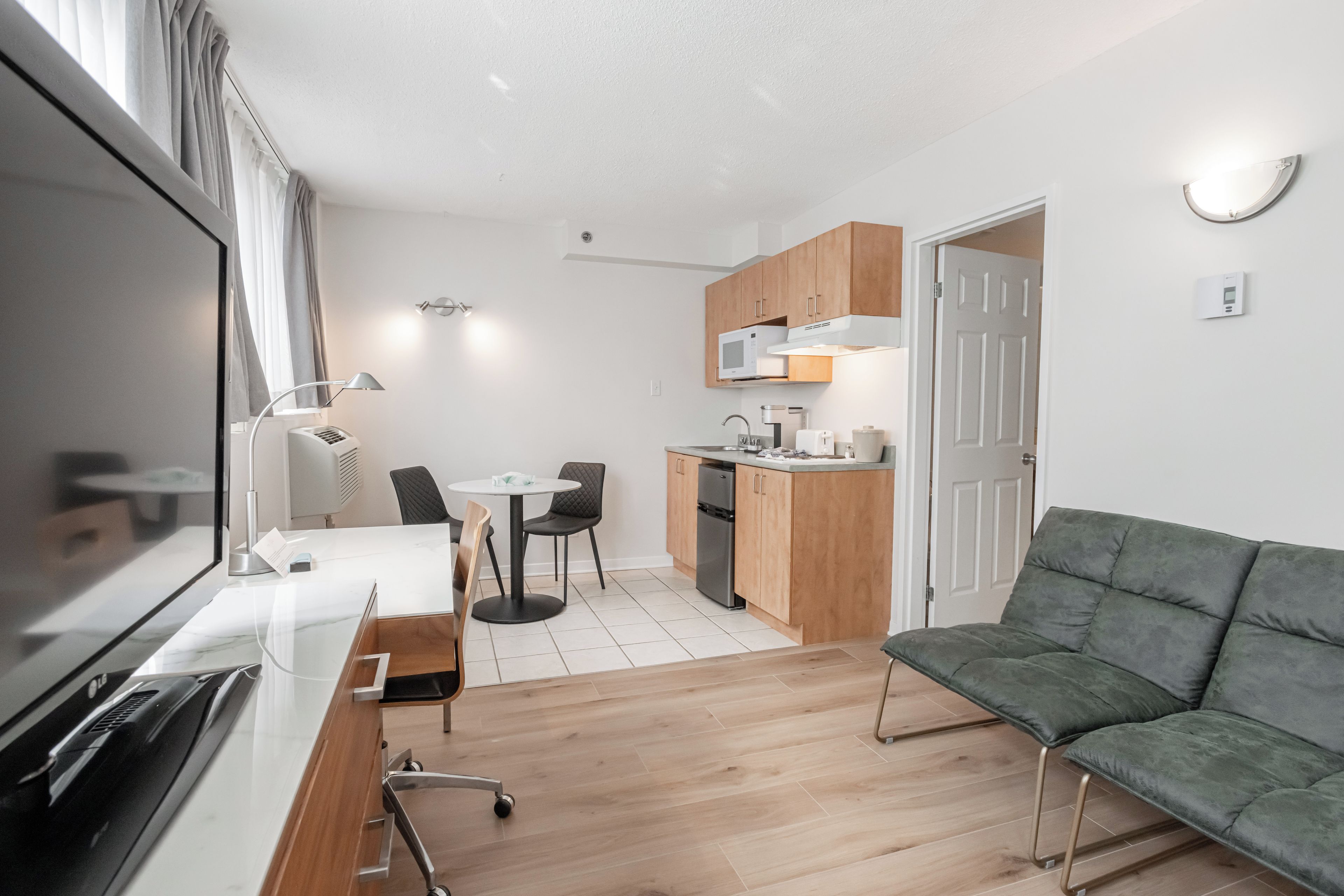 A compact living space with a kitchenette, a dining area, and a seating area.