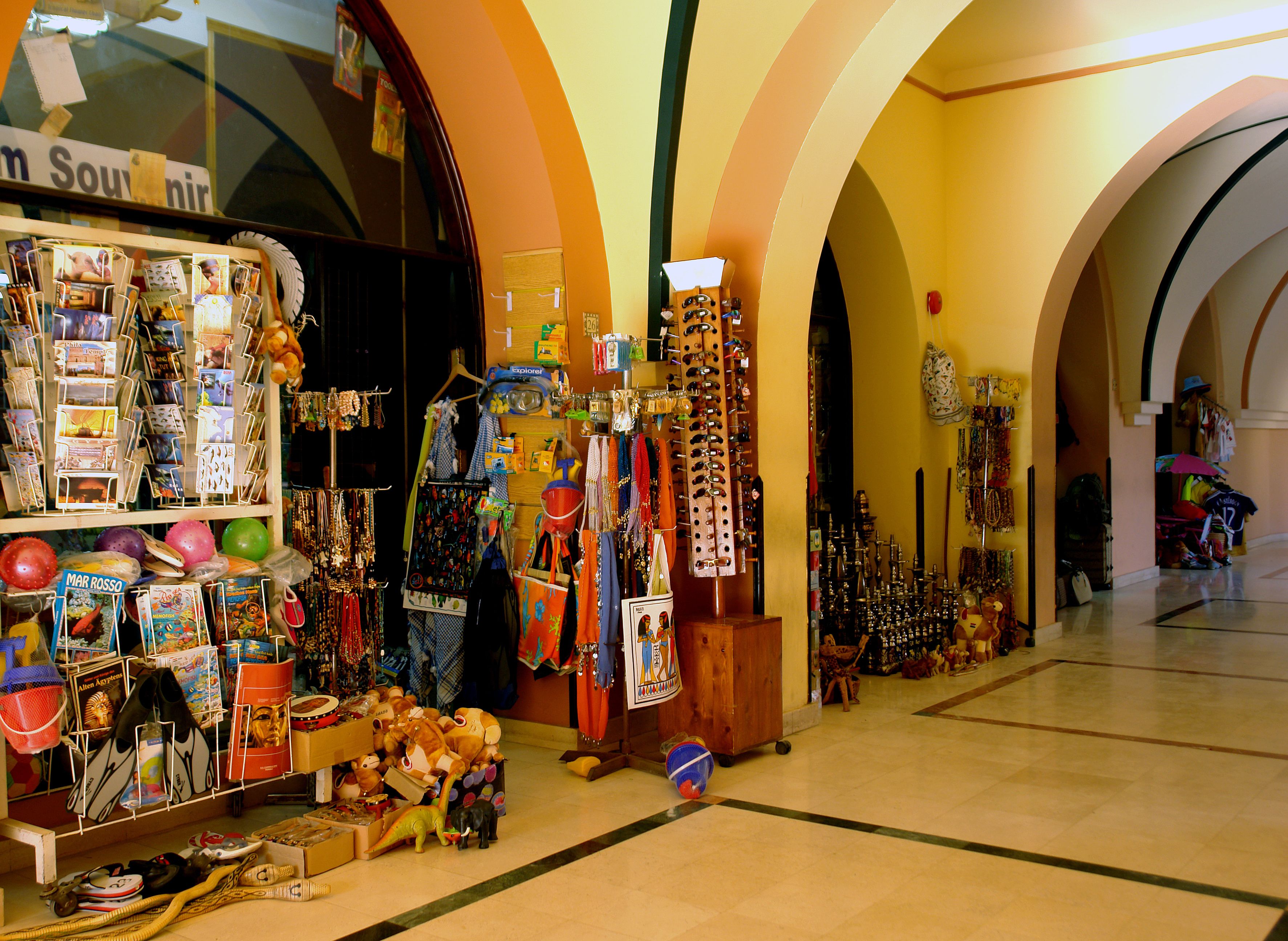 A brightly lit souvenir shop with various items on display, including toys, jewelry, and postcards.