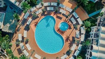 Una piscina al aire libre, tumbonas