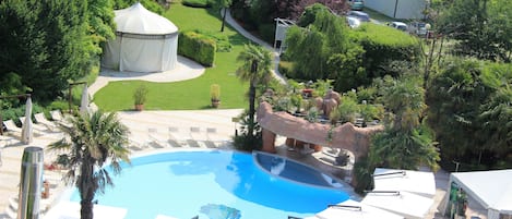 Una piscina al aire libre de temporada, sombrillas, tumbonas