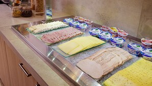 A buffet with various food items including meats, cheeses, and yogurt.