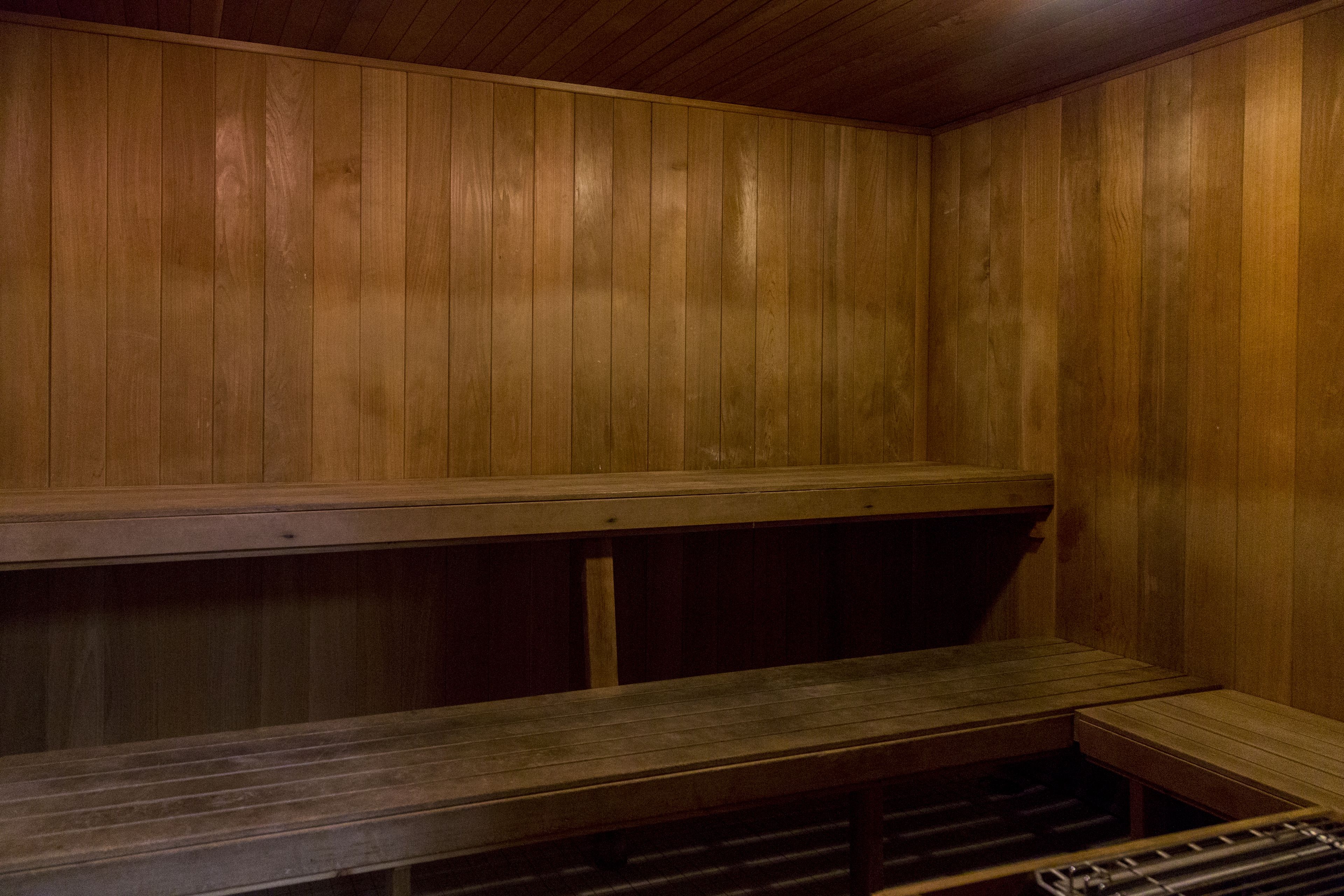 Een houten sauna met banken en een zitbank.