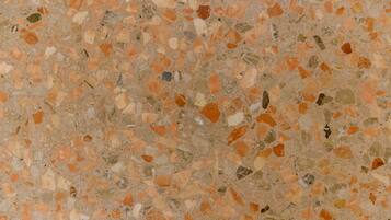 A terrazzo floor with a mix of beige, brown, and green tiles.