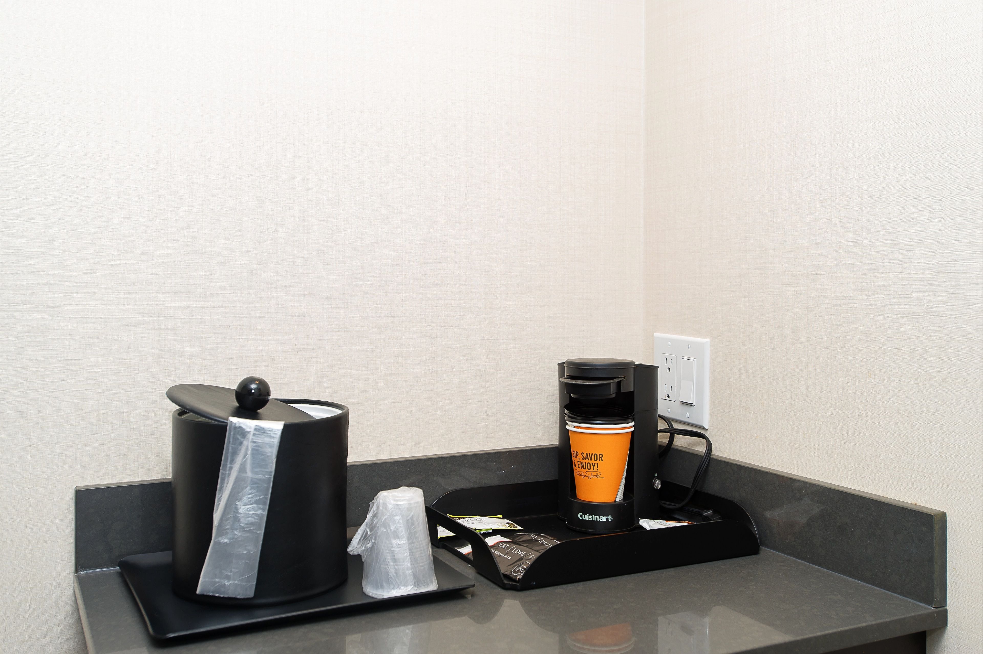 A coffee machine and a disposable cup on a countertop.