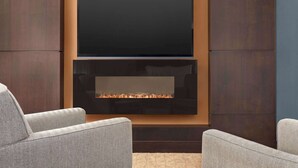 Una sala de estar moderna con un televisor de pantalla plana sobre una chimenea.