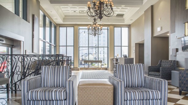 A spacious lobby with striped armchairs, a central ottoman, and a chandelier. - Comfort Inn Fallsview (Niagara Falls)