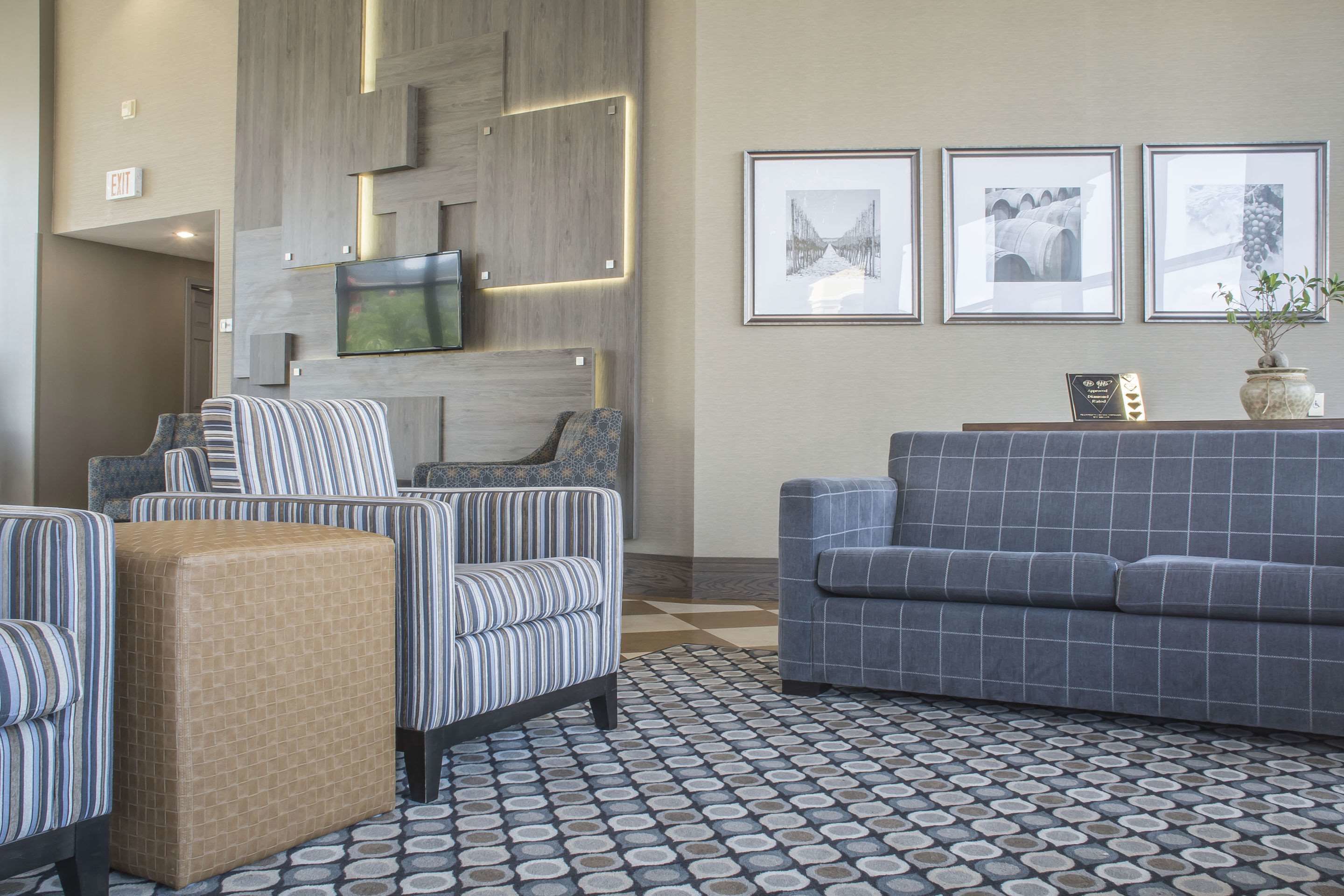 Een moderne woonkamer met gestreepte fauteuils, een blauwe bank en een vloer met een patroon.