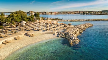Playa en los alrededores, camastros, sombrillas y 2 bares en la playa