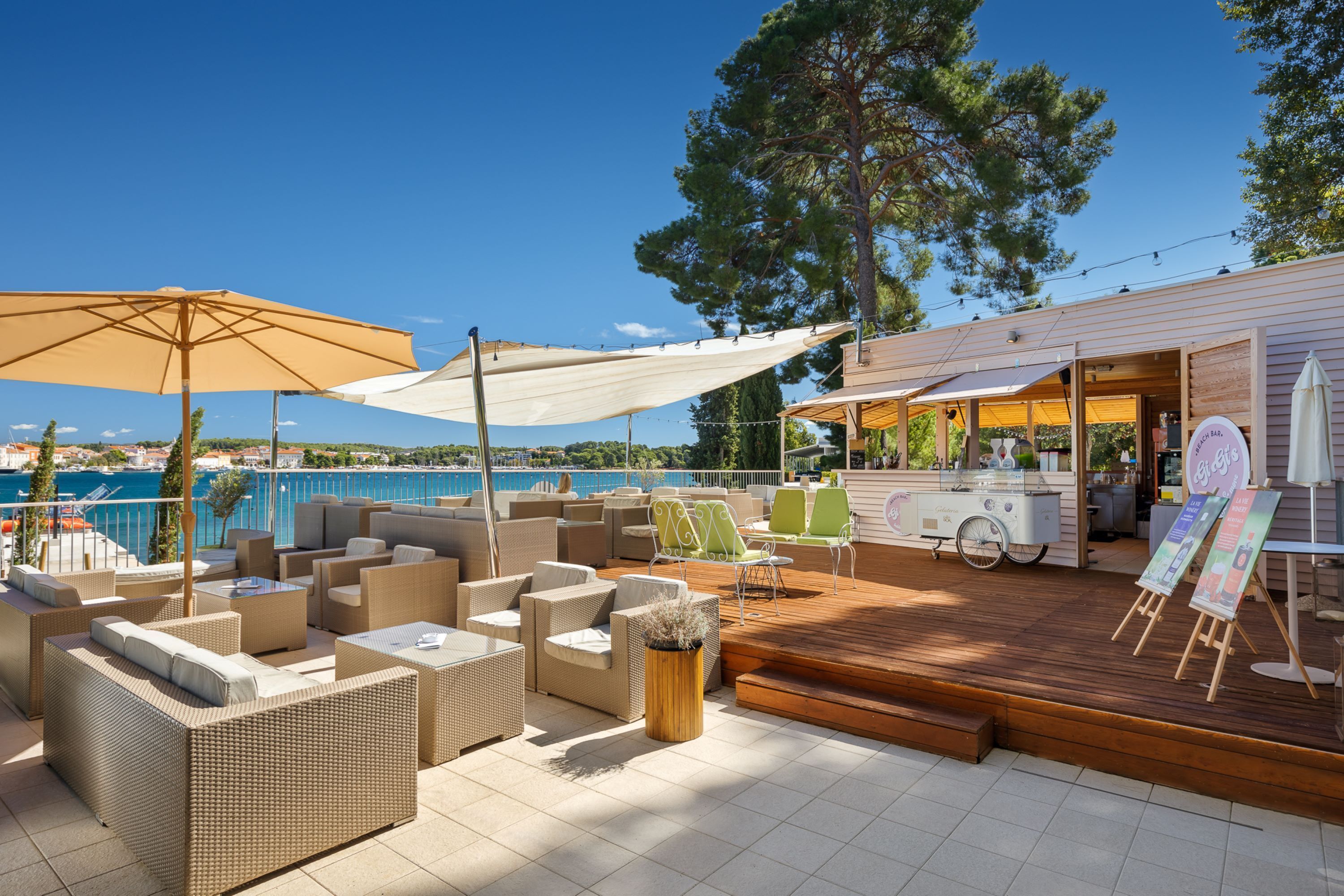 A rooftop bar with outdoor seating, a pool view, and a wooden deck.
