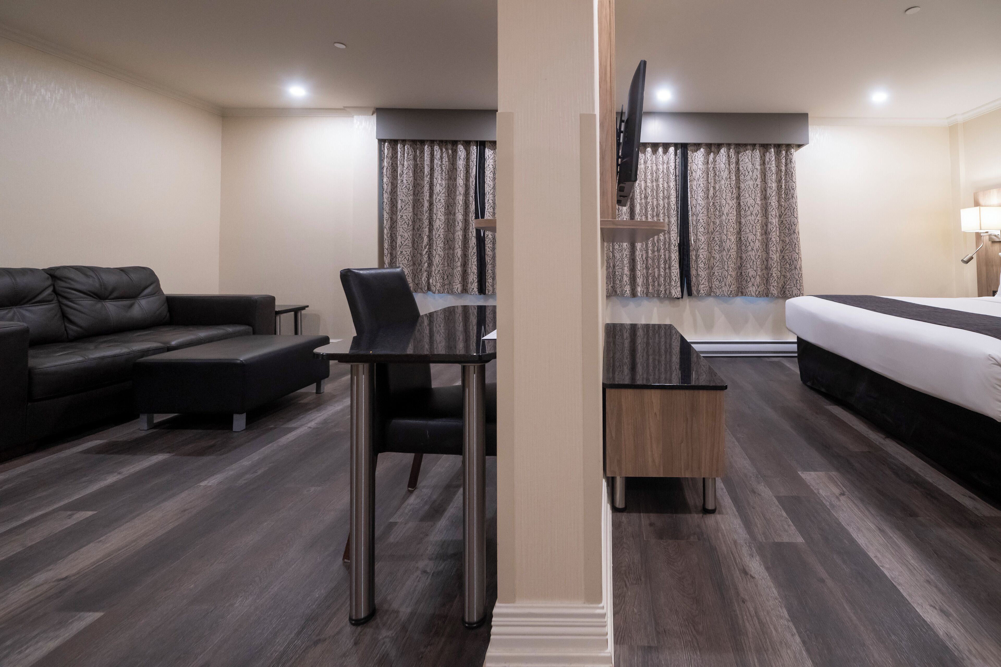 Une chambre d’hôtel moderne équipée d’un canapé, d’un bureau, d’un lit et d’une télévision.