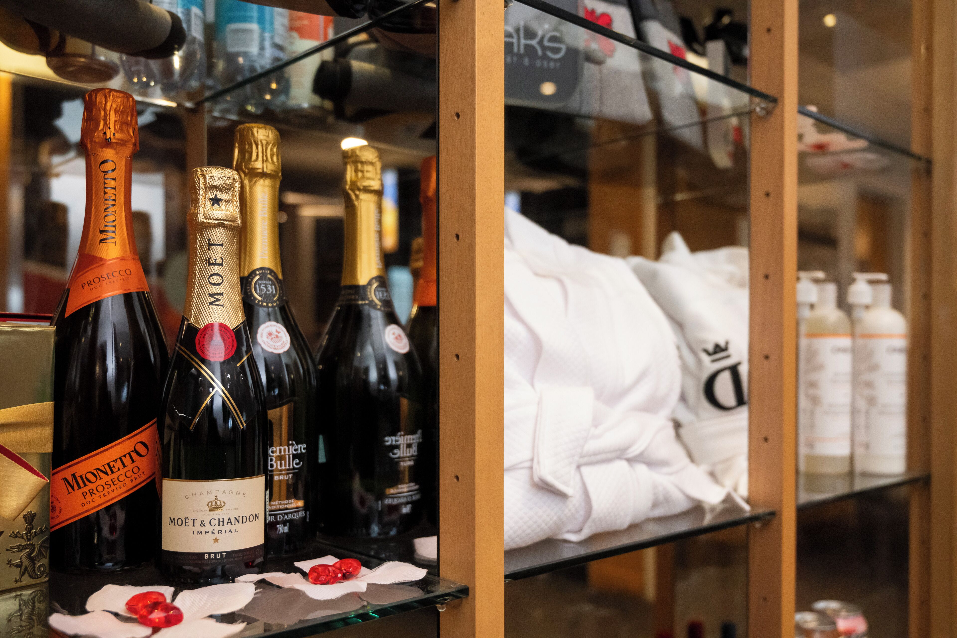 Une étagère avec des bouteilles de champagne et une robe blanche.