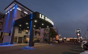 Ein Hotel mit Eingangsbereich und überdachtem Zugang sowie beleuchteter Beschilderung.