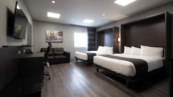 Una habitación de hotel moderna con una cama grande, un escritorio, una silla y un televisor de pantalla plana montado en la pared.