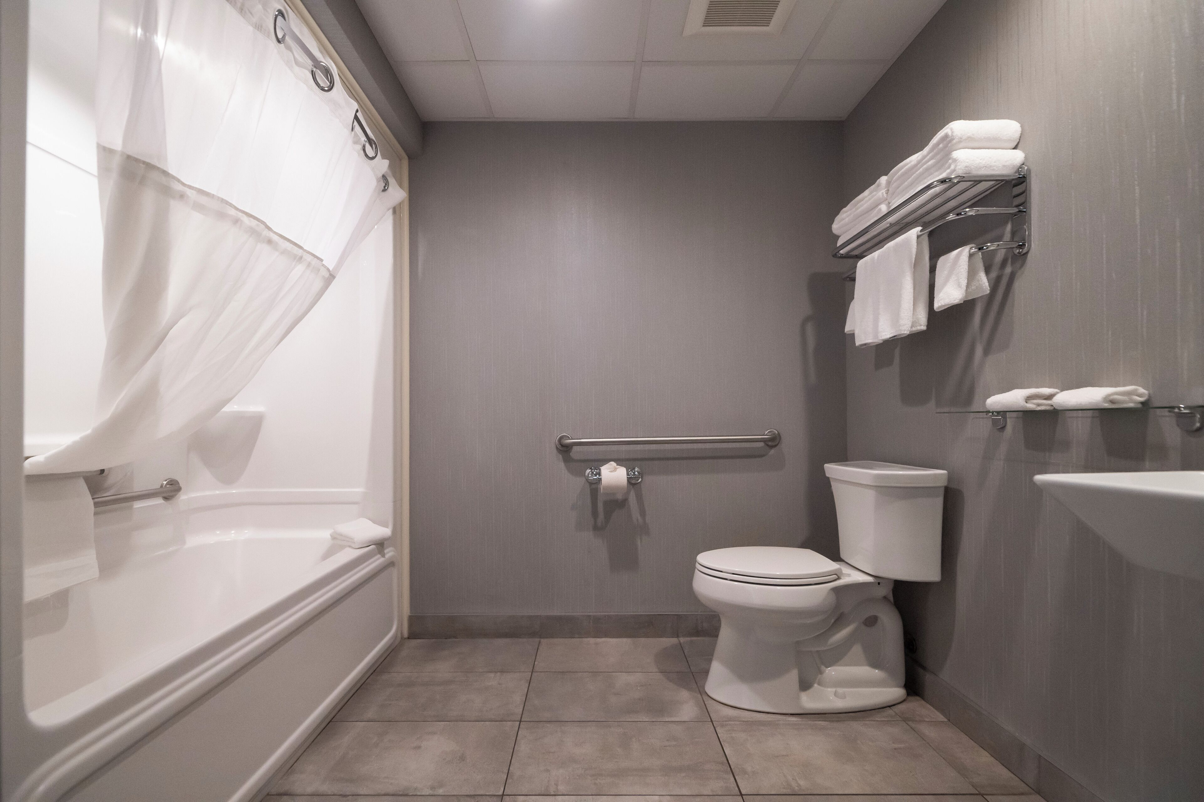 A modern bathroom with a bathtub, toilet, and sink.