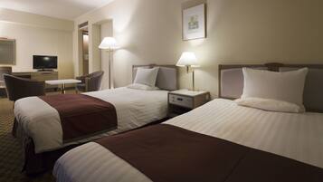 Een hotelkamer met twee bedden, een bureau, een stoel en een televisie.