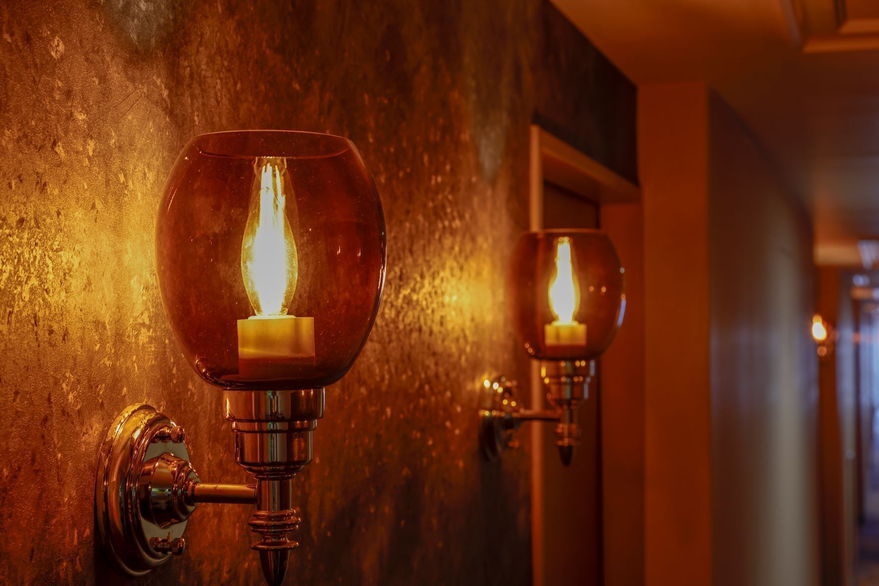 A wall-mounted light fixture with a candle-like flame design.