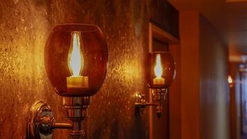 A wall-mounted light fixture with a candle-like flame design.