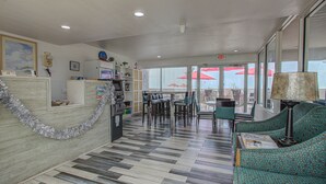 A hotel lobby with a check-in counter, seating area, and a view of the outside. - The Beach House Inn (Daytona Beach)