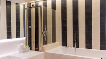 Ein modernes Badezimmer mit einer gläsernen Dusche, einer weißen Badewanne und einem großen Spiegel.