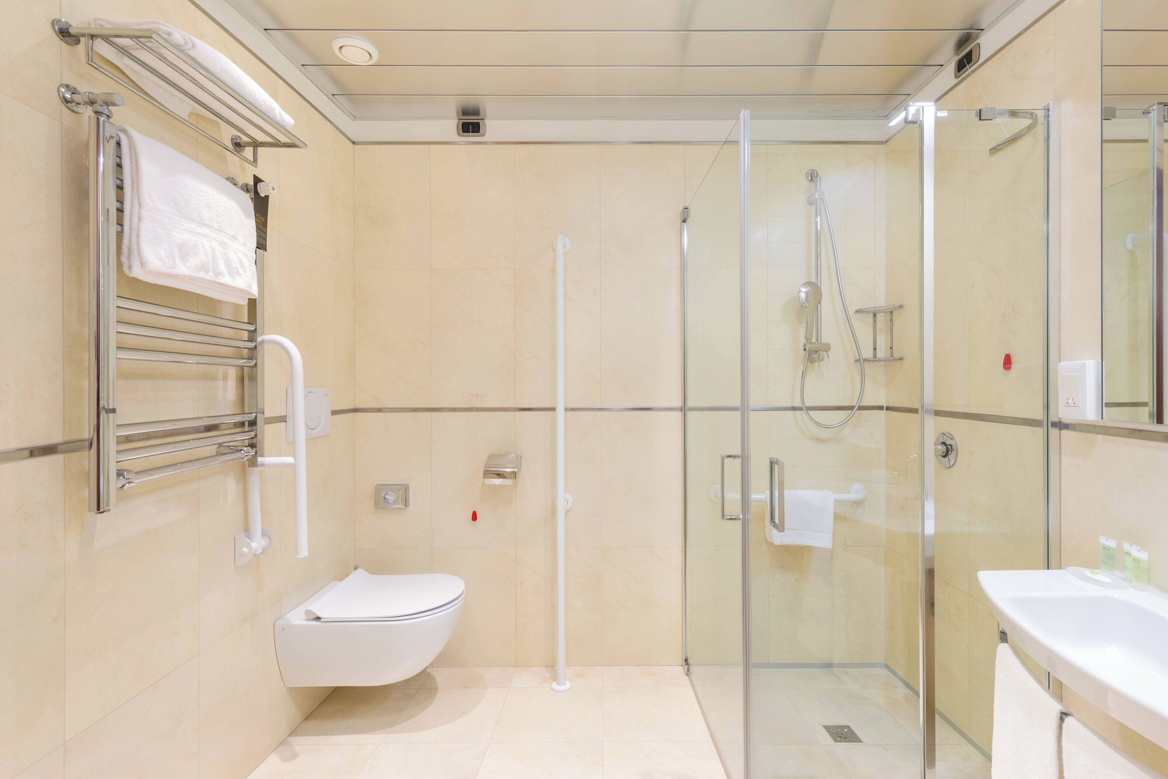 A modern bathroom with a glass-enclosed shower, a toilet, and a sink.