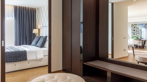 Een moderne hotelkamer met een bed, een grote spiegel en een houten garderobe.