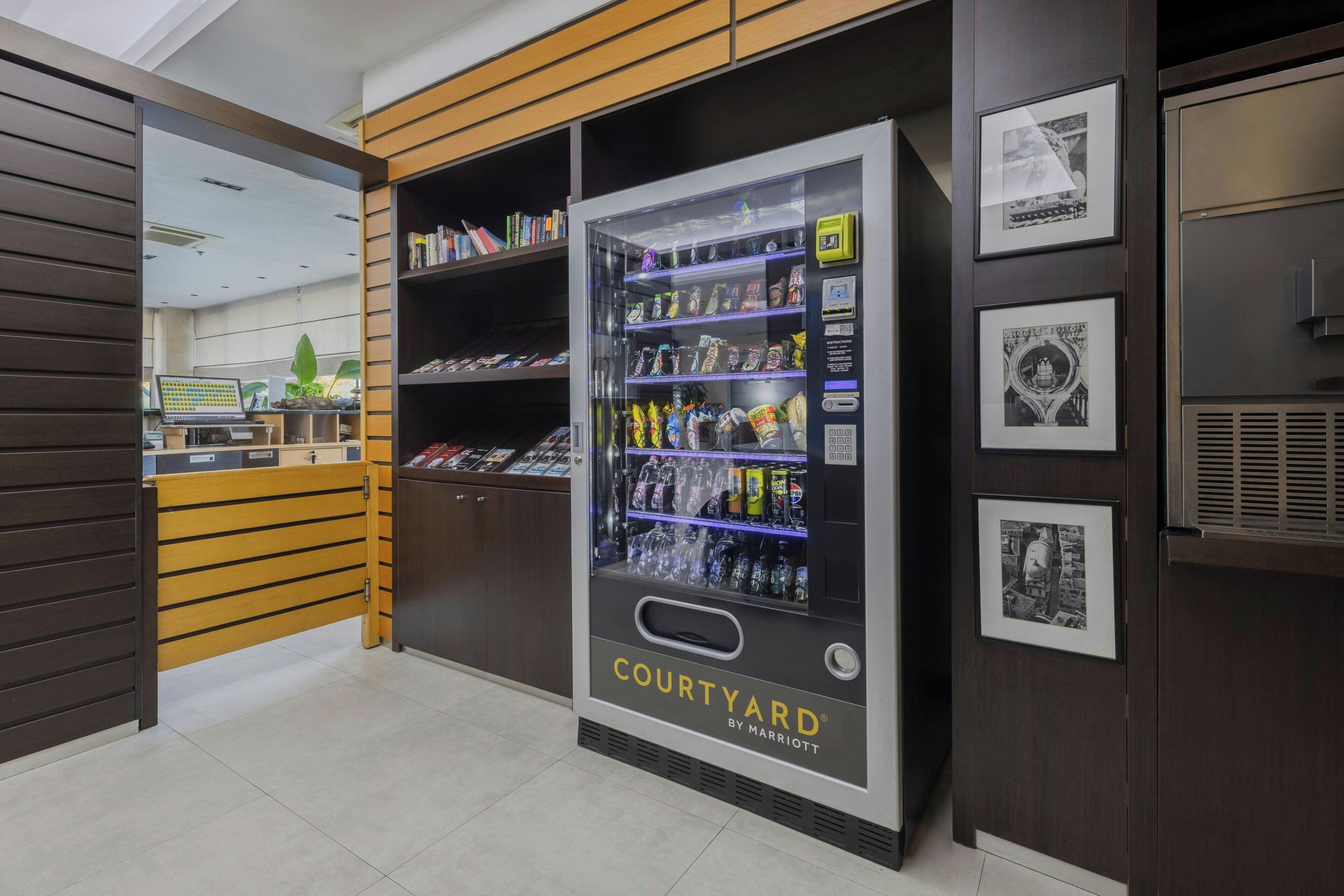 A vending machine labeled 'COURTYARD BY MARRIOTT' with various snacks and drinks.